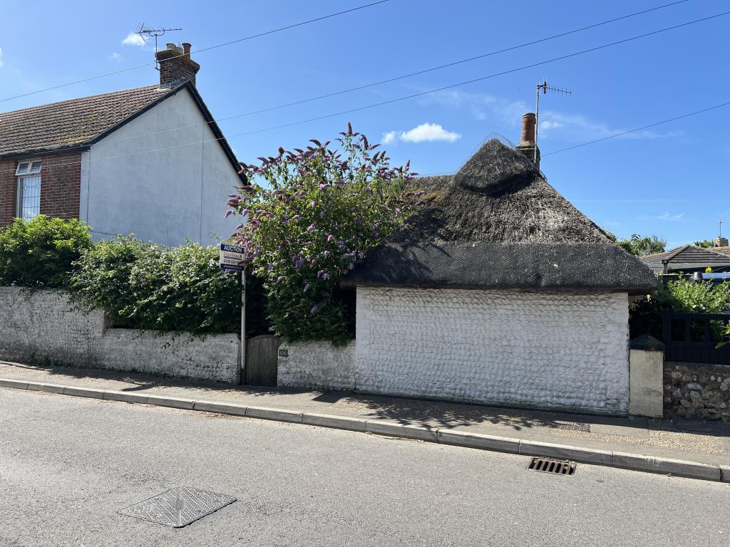 Lot: 138 - TWO-BEDROOM THATCHED COTTAGE FOR OCCUPATION OR INVESTMENT - Road view of thatched cottage